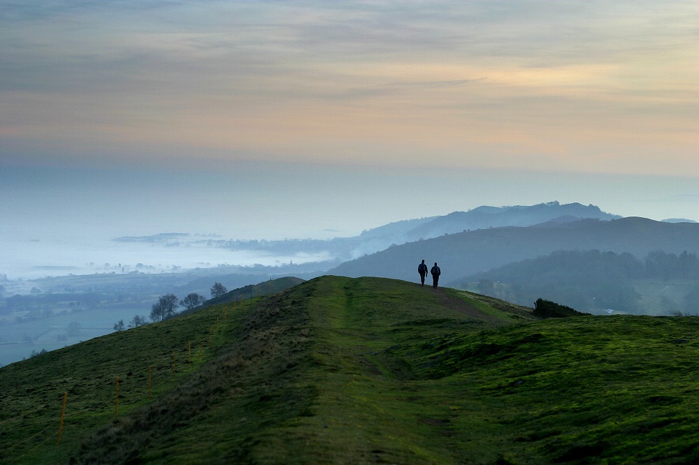 Two Figures Walking Over Pinnacle Hill In The Sunset